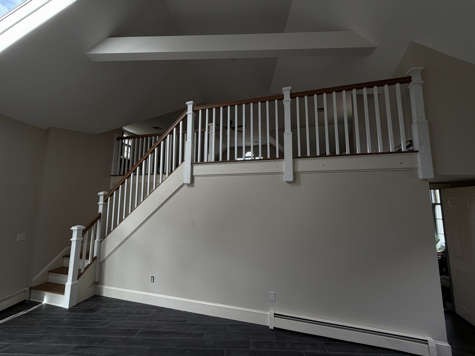 Custom red oak staircase with painted white risers, square newel posts and an open white-baluster railing in Rehoboth, Massachusetts.
