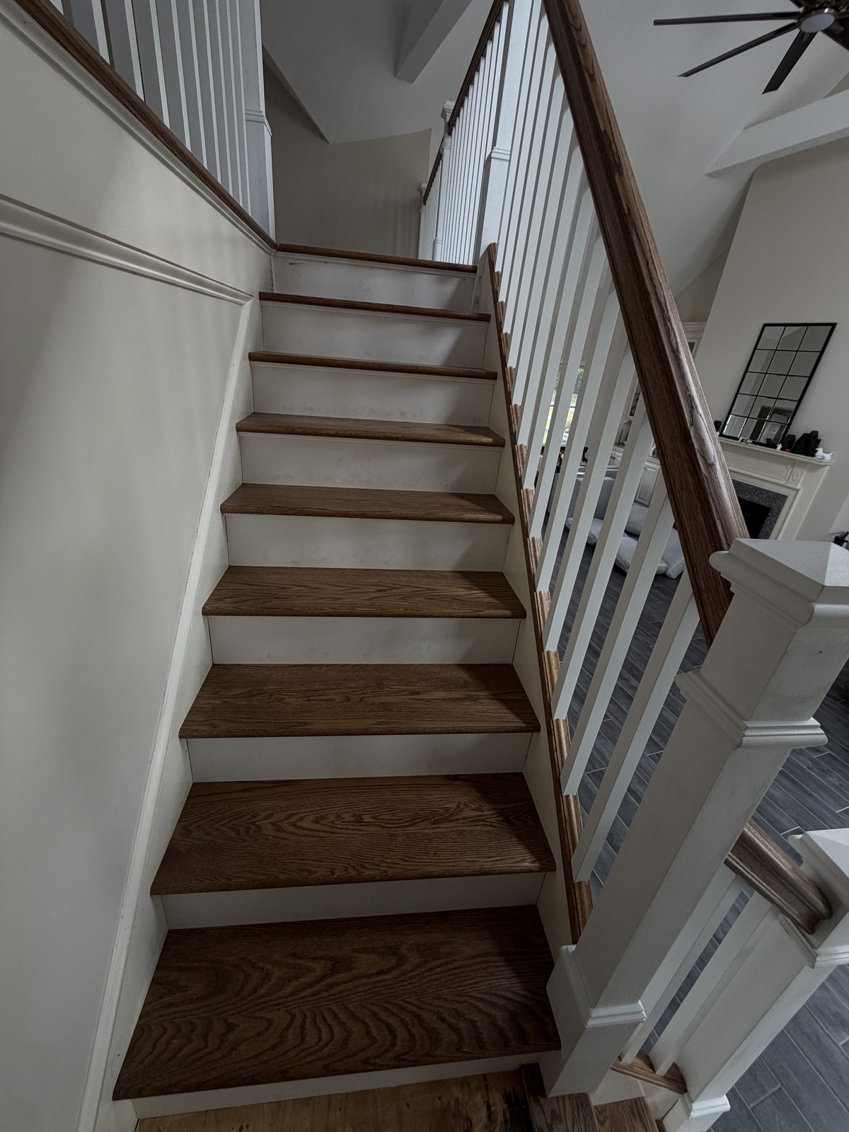 Looking up the Rehoboth staircase during the rebuild, with red oak treads, painted white risers and the red oak handrail in place.