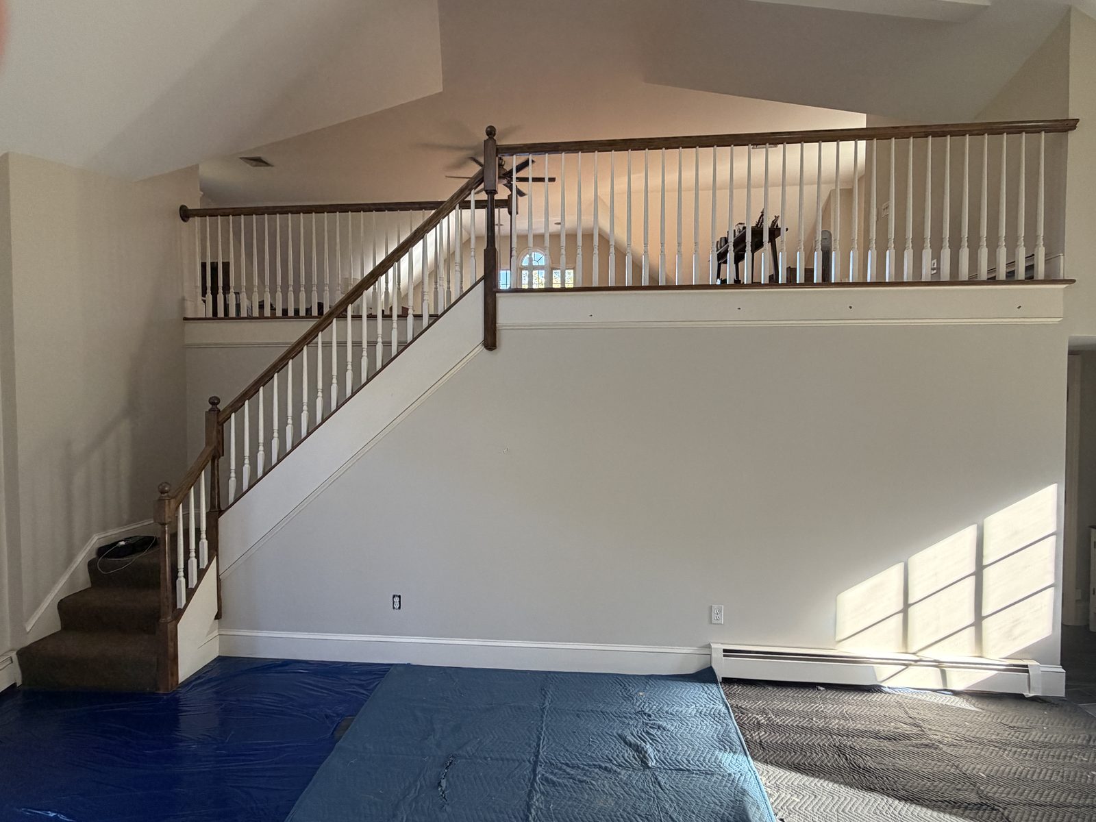 Original carpeted staircase with dark stained railings and turned white balusters before the custom red oak rebuild in Rehoboth, Massachusetts.