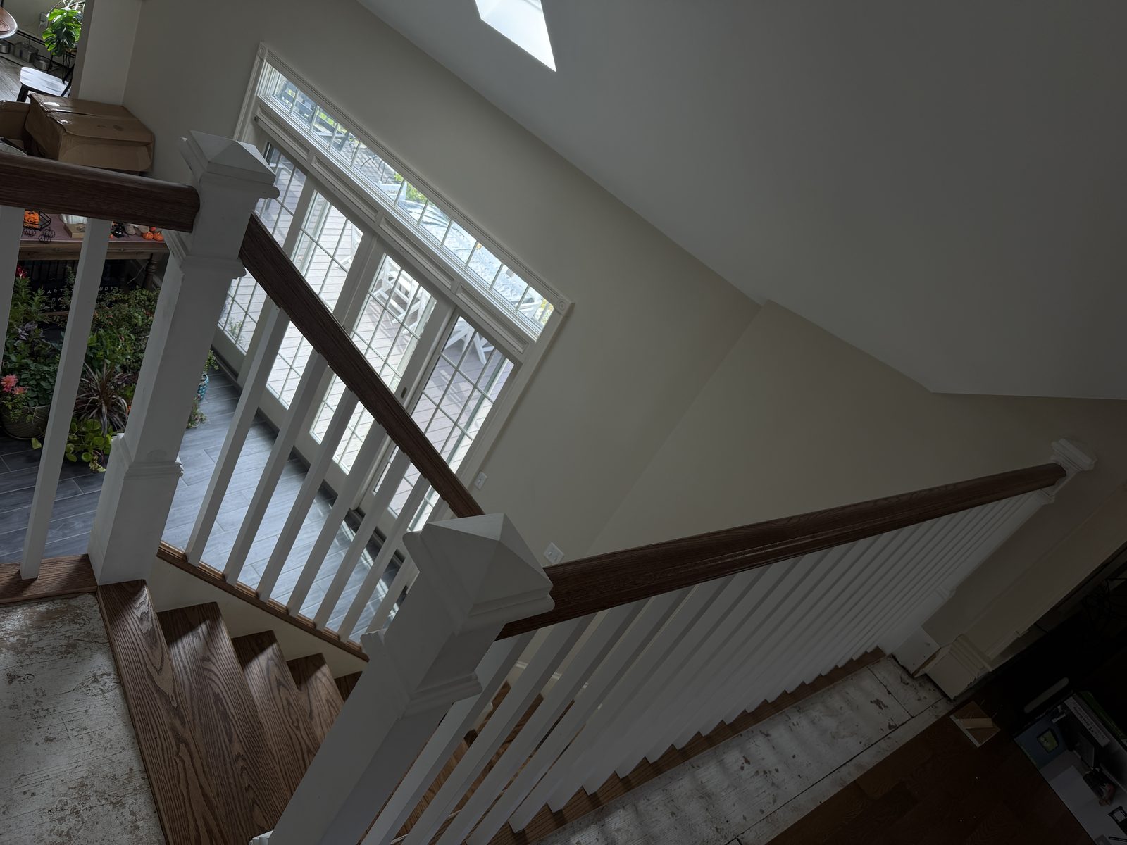 View down from the upper landing along the red oak handrail, newel posts and treads during the Rehoboth staircase rebuild.