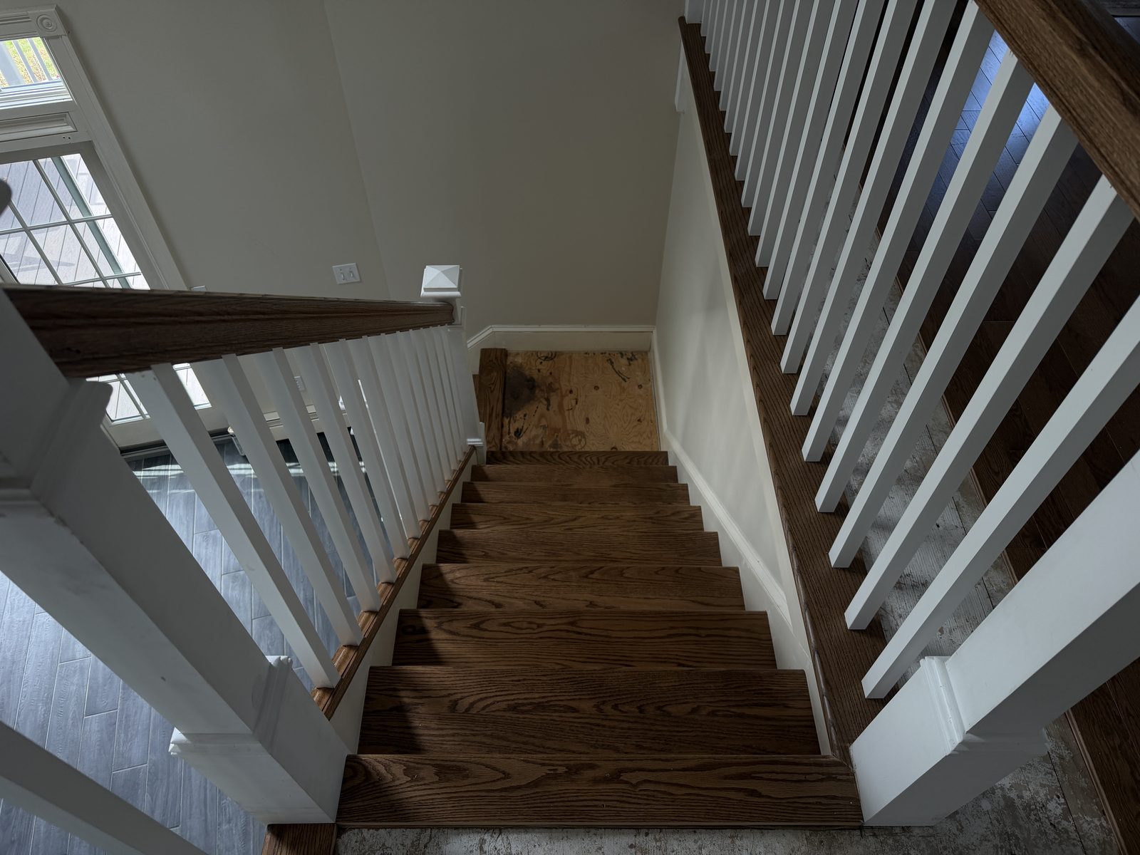 Looking down the Rehoboth staircase with red oak treads, white balusters and handrails in place.