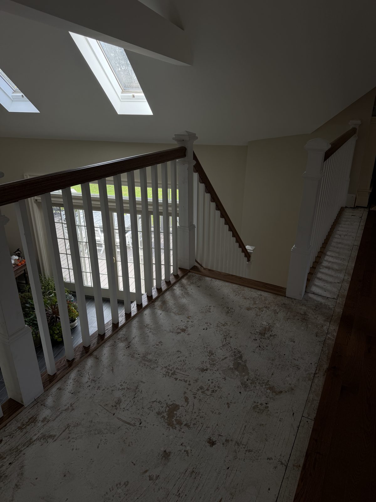 Upper landing with a newly installed red oak handrail, square newel posts and white balusters during the Rehoboth staircase rebuild.